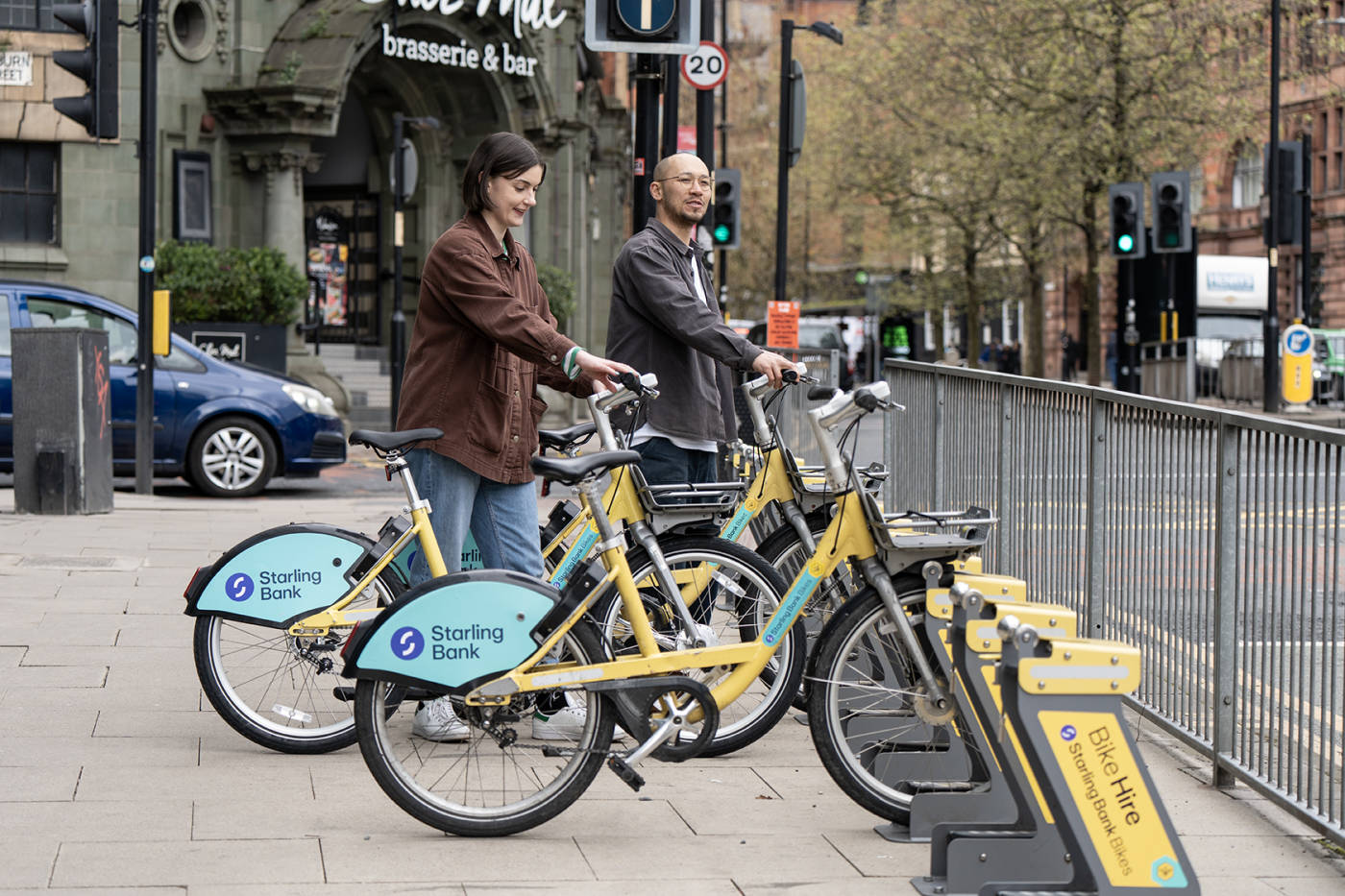 Two people docking their starling bank bikes