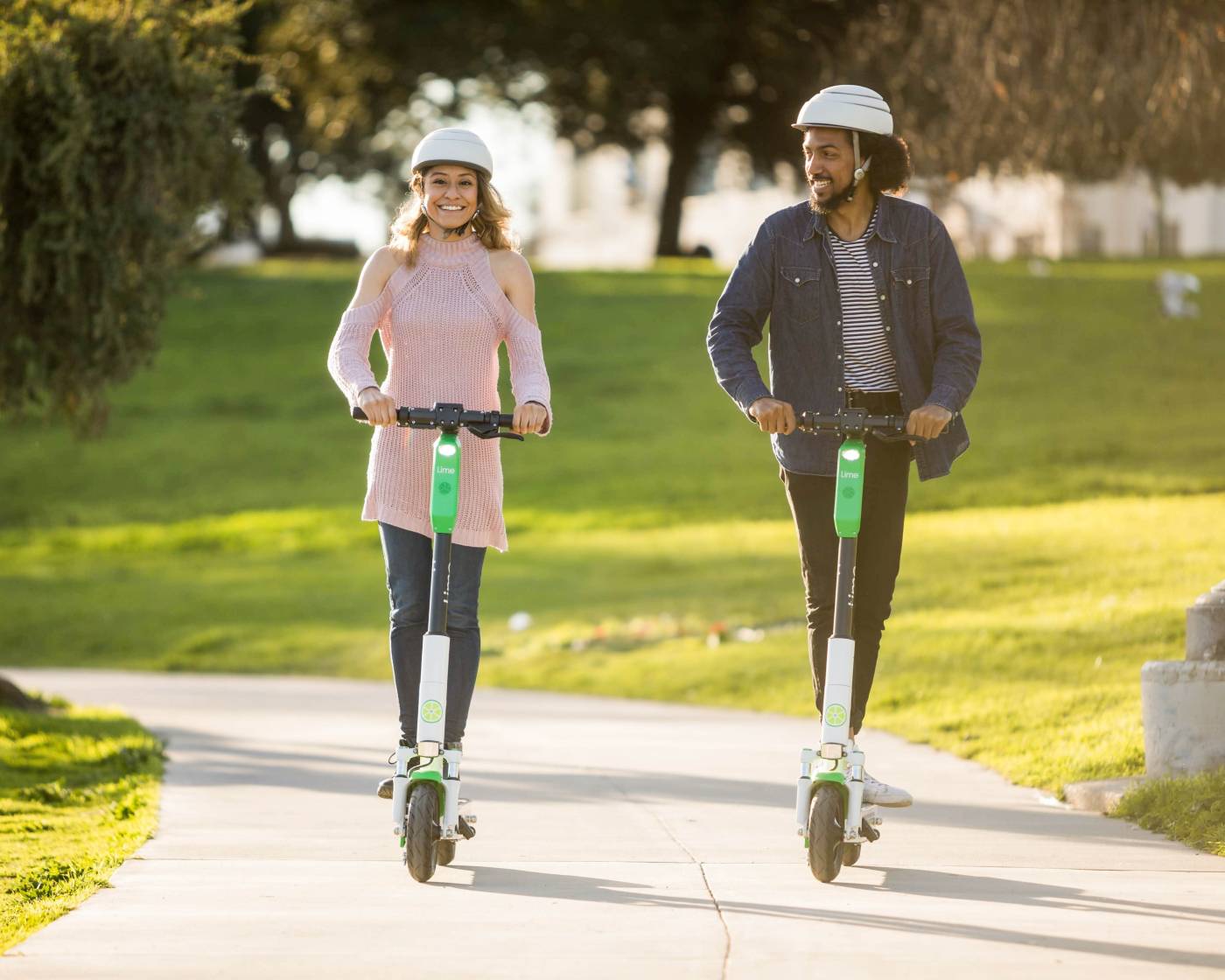 Woman and man riding Lime eScooters 