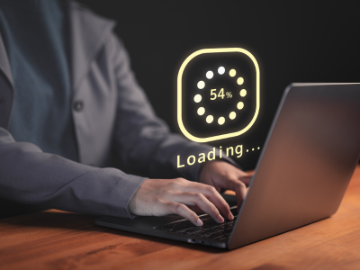 Man sat at desk on laptop with loading wheel icon showing slow internet speeds due to ISP throttling