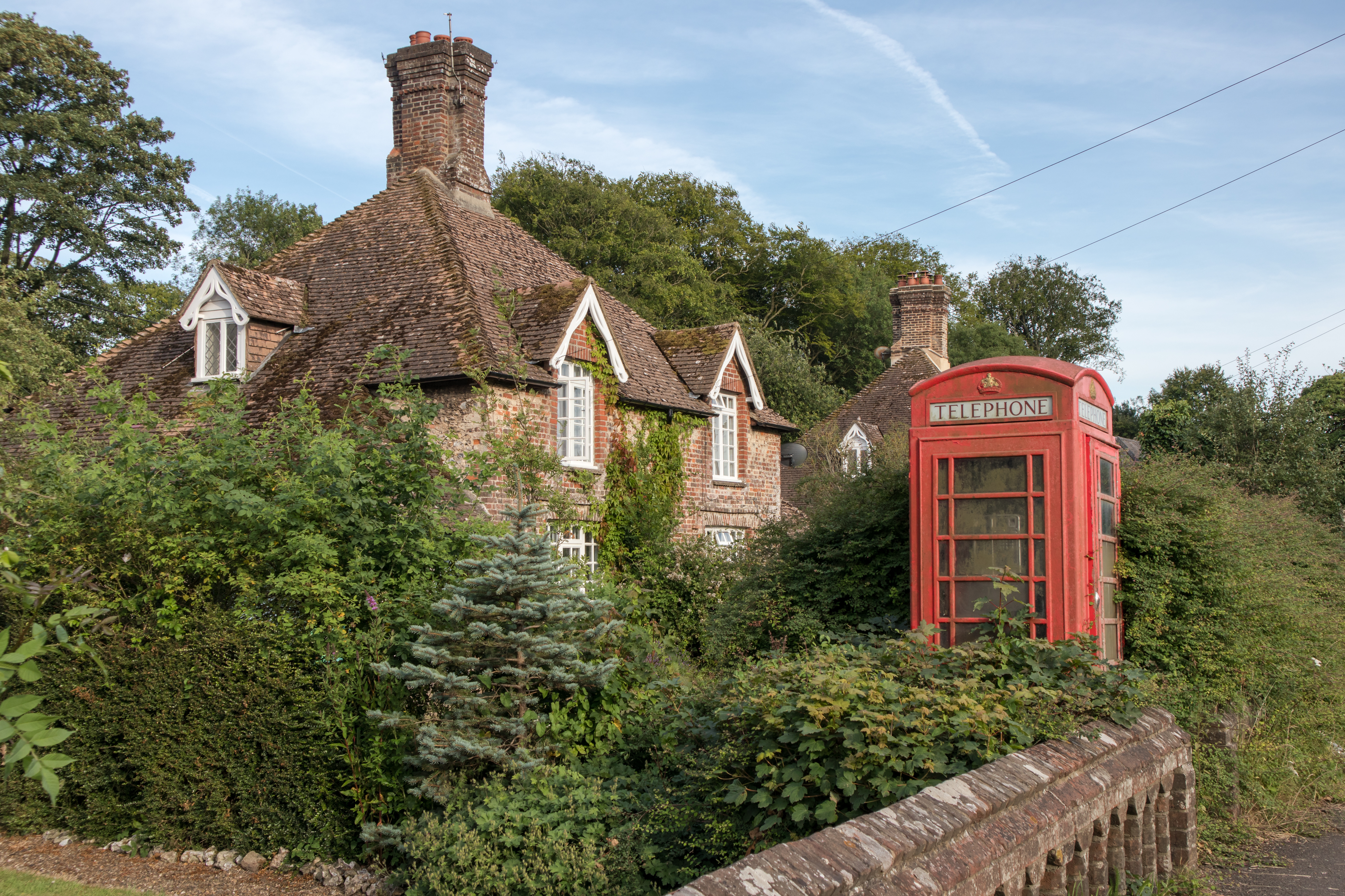 Cottage in idyllic rural English village with old red telephone box in front