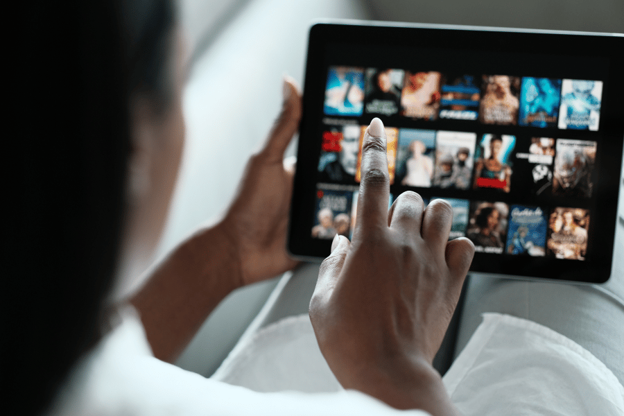 Woman browsing on tablet looking at streaming media