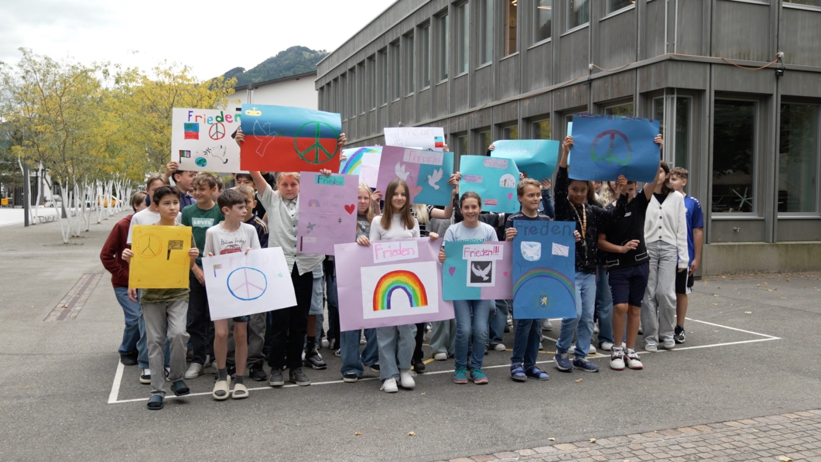 Liechtenstein school class stomps with posters for peace.