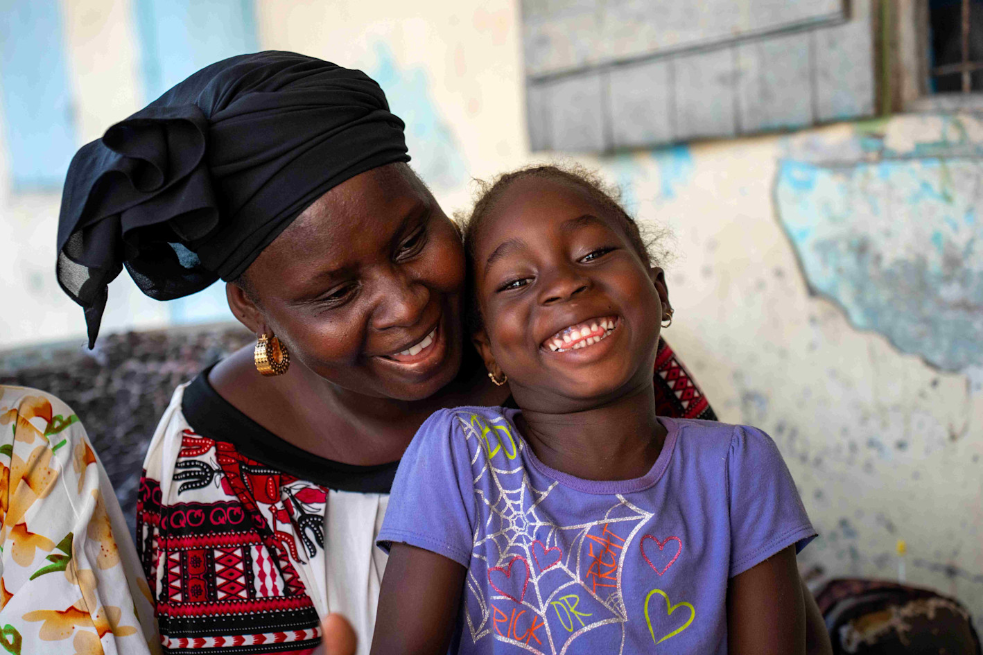 Kleines Mädchen lachend mit seiner Mutter im SOS-Kinderdorf Gambia, Bakoteh