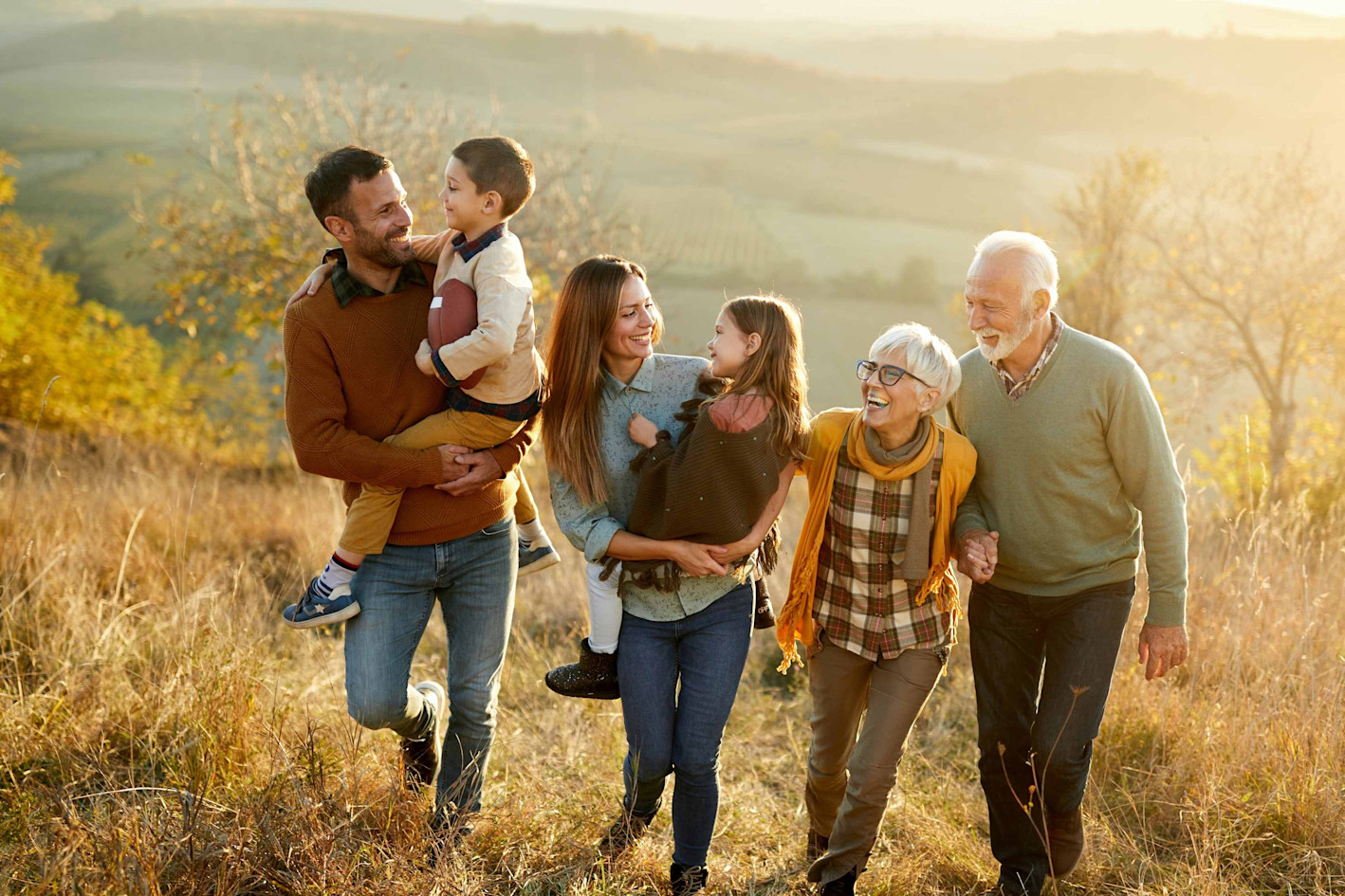 Families with three generations in an autumnal field