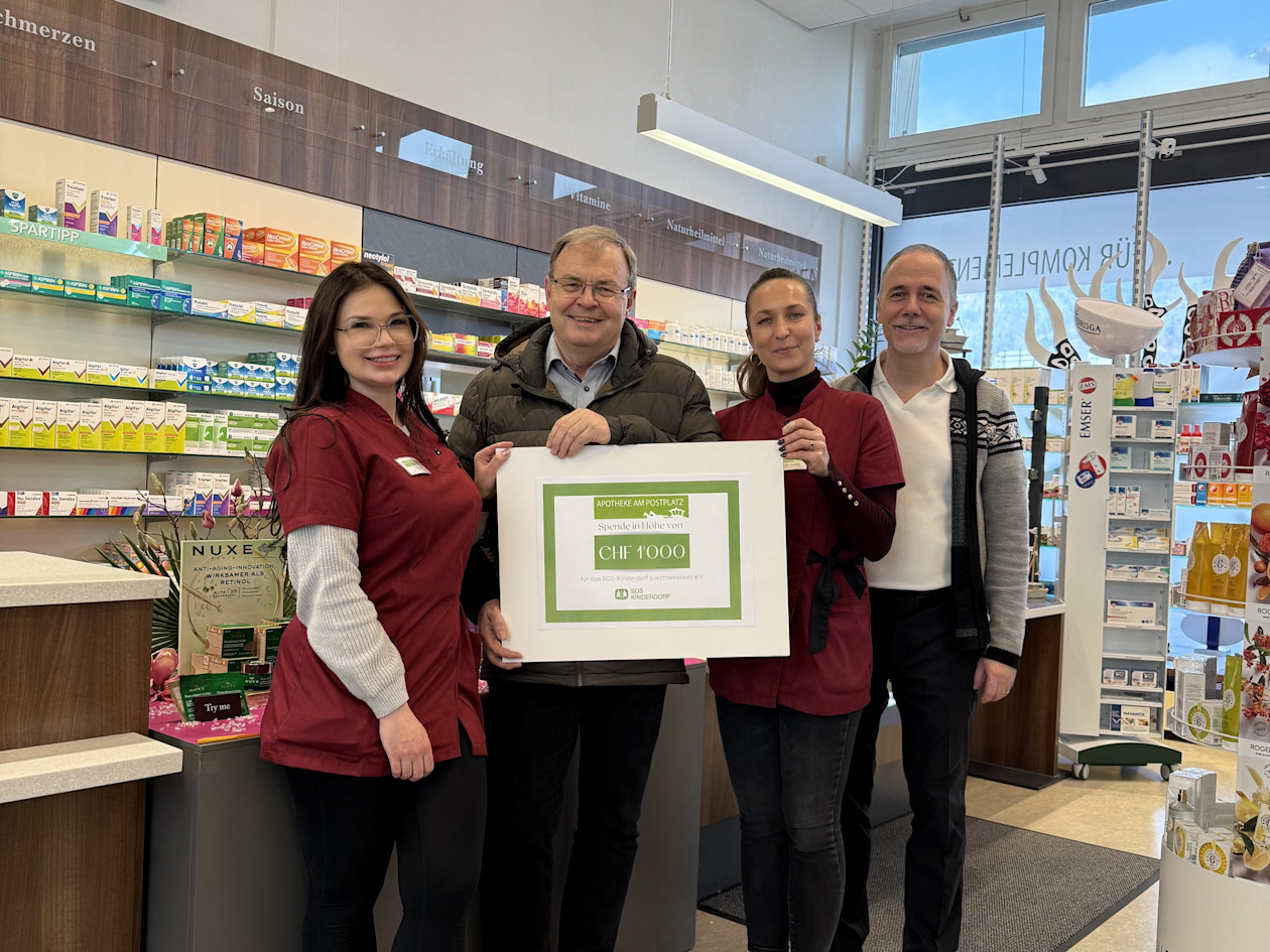 Kristina Lang (Mitarbeiterin Apotheke), Markus Schaper (SOS-Kinderdorf), Ula Ziet-ka (Mitarbeiterin Apotheke), Nikolaus Frick (Inhaber Apotheke) bei der Checkübergabe in der Apotheke am Postplatz in Schaan