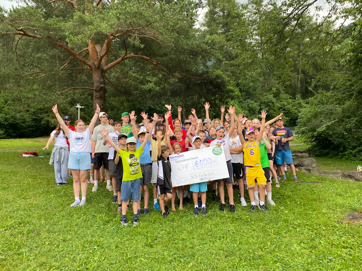 Kinder der formatio Privatschule mit dem Check von CHF 6000 jubelnd. 