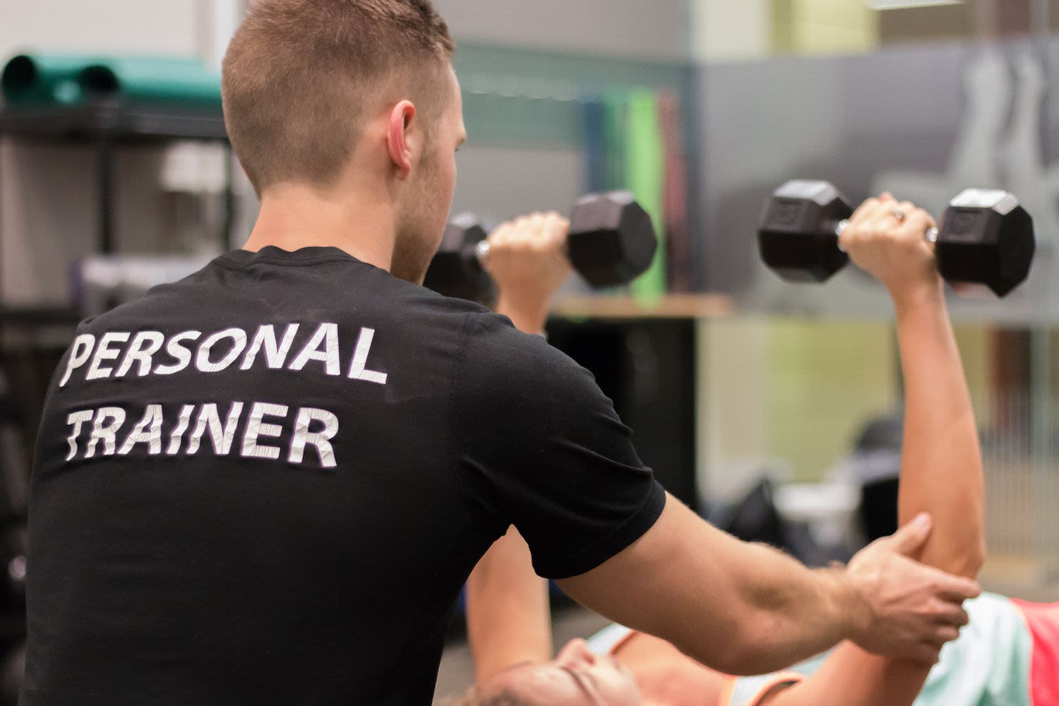 Personal trainer assisting a client