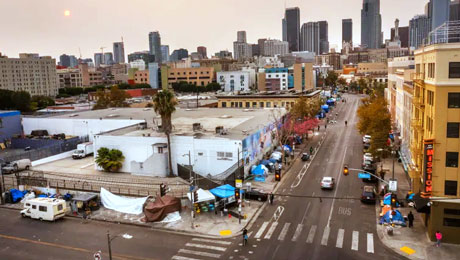 Los Angeles skyline with homeless camp in the foreground
