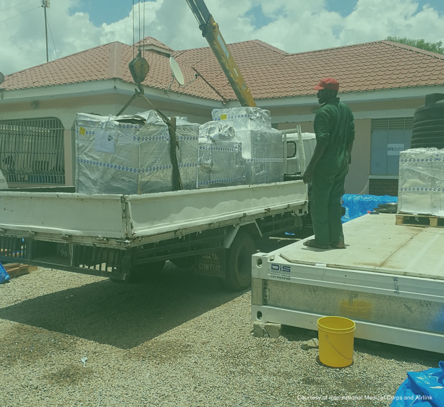 Person loading equipment on a truck with a crane