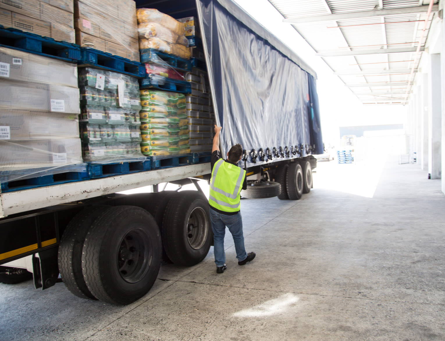 A person walking in front of a truck that is filled with supplies