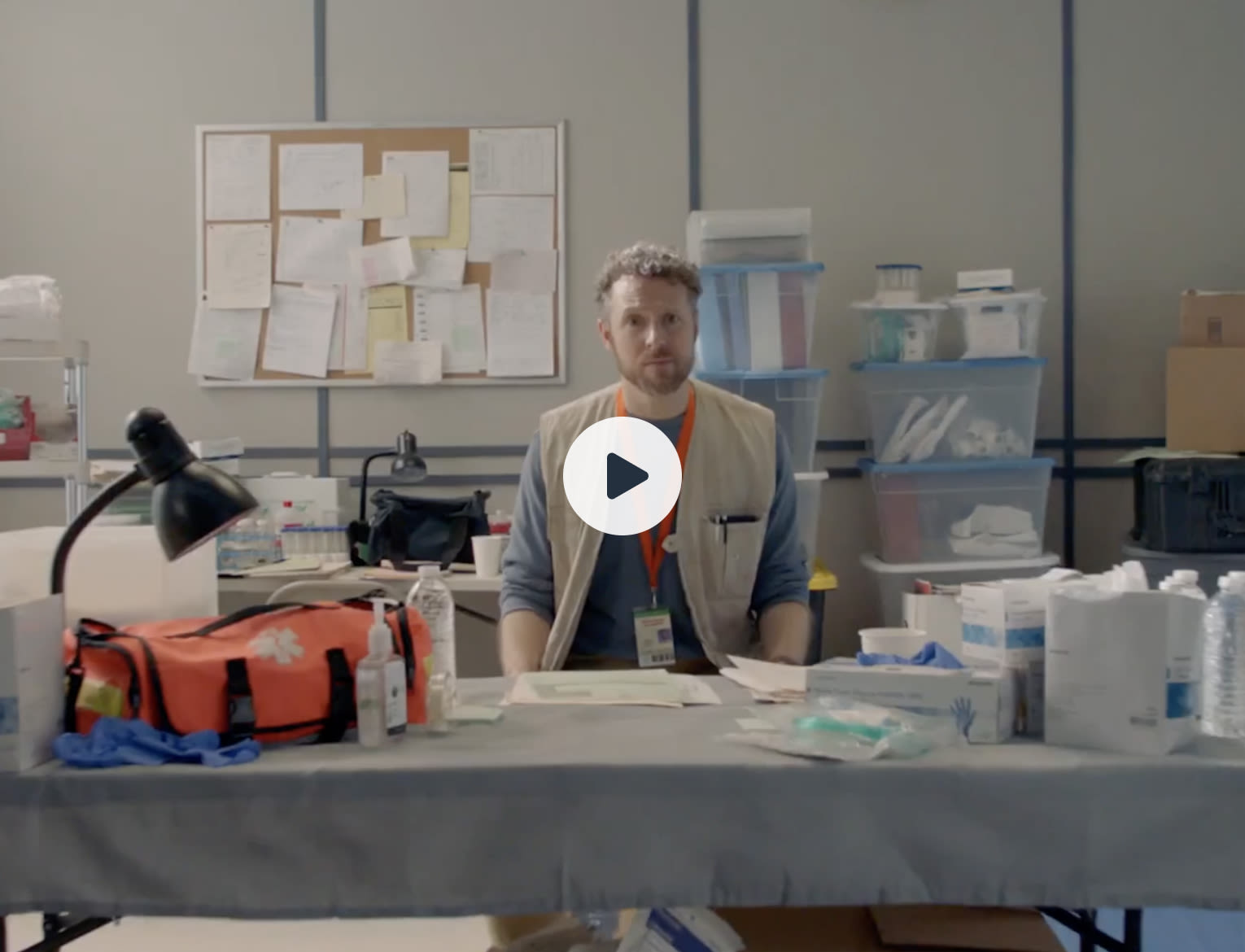 Person behind a table that is filled with medical supplies