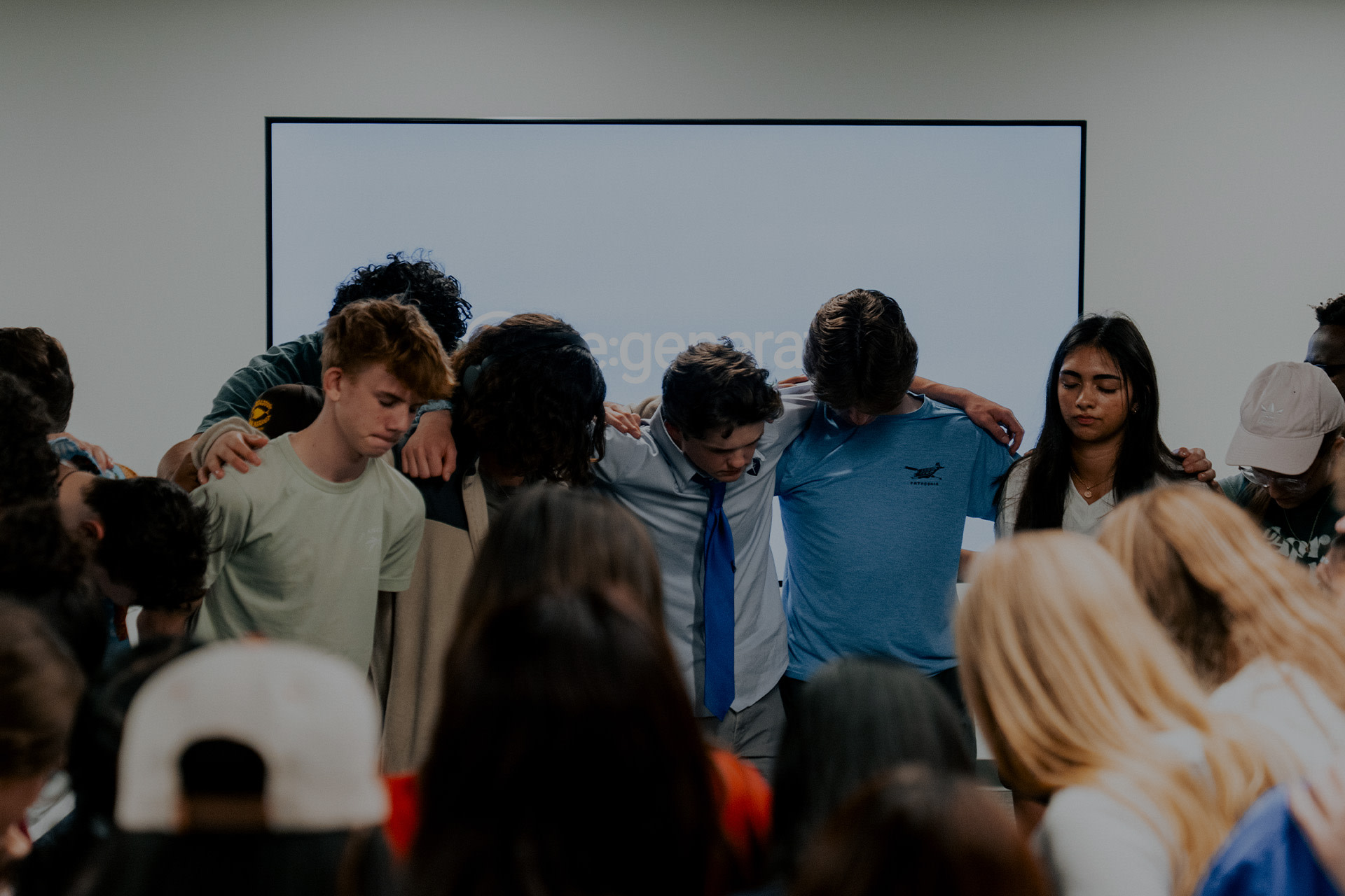 Students gather in prayer during Re:generation for Students, seeking Christ together in a safe and supportive environment.
