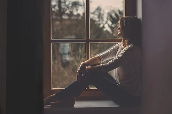 Woman sitting next to a window