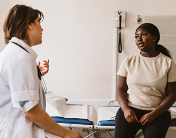 Patient assis sur une table d’hôpital parlant avec un médecin