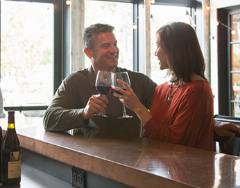 Couple au bar dégustant un verre de vin