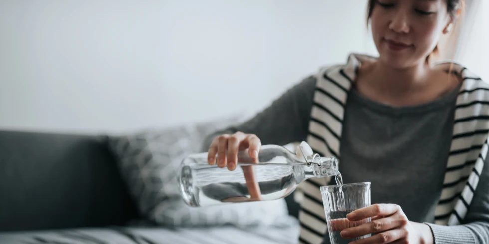 Femme versant de l’eau dans un verre