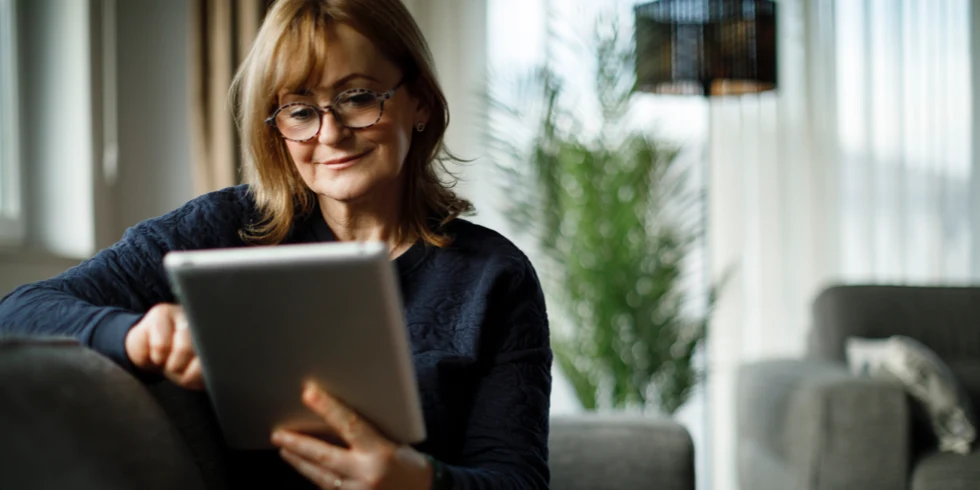 Femme à lunettes faisant des recherches sur une tablette