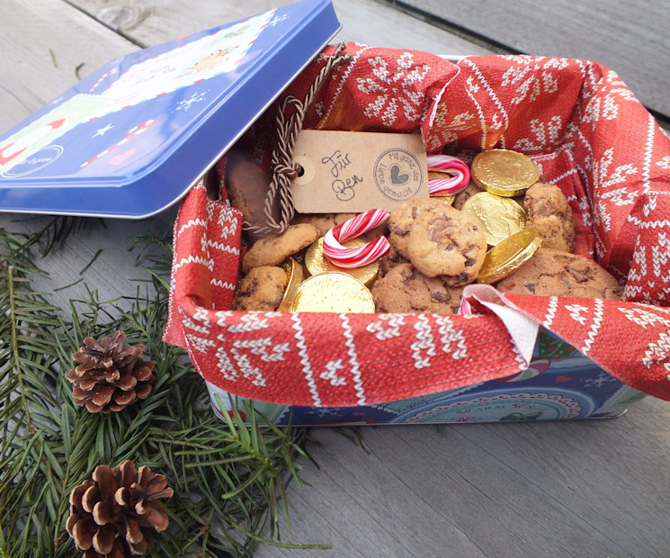 Plätzchen liebevoll verpacken in einer weihnachtlichen Geschenkdose