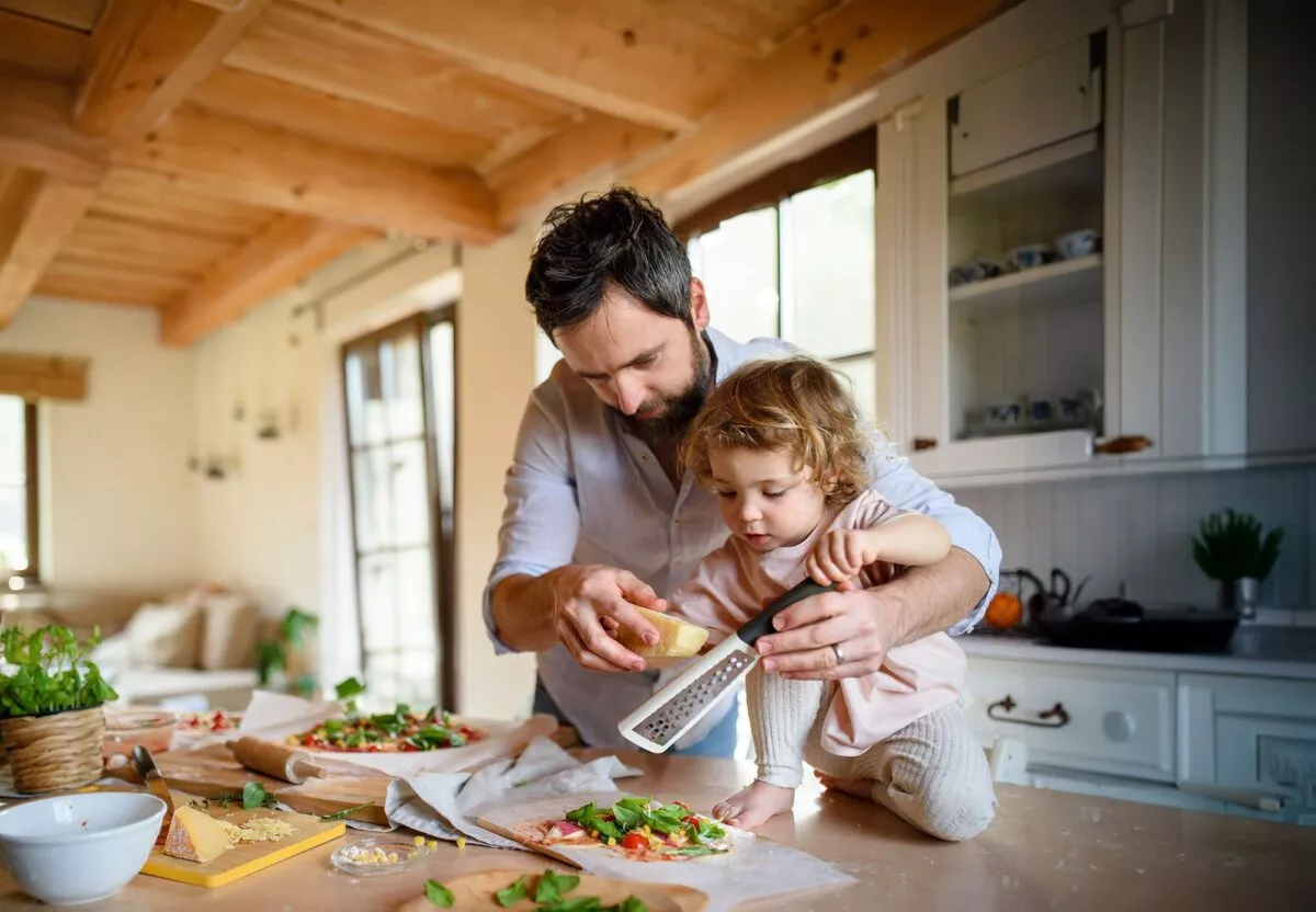 Un père et son enfant râpent du parmesan.
