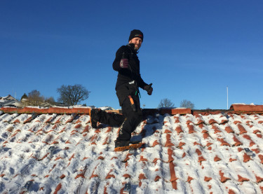 Jonas Gustafsson från Wettersol monterar solpaneler på ett tegeltak