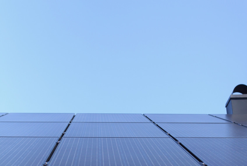 Solceller på sommaren med en blå himmel i bakgrunden