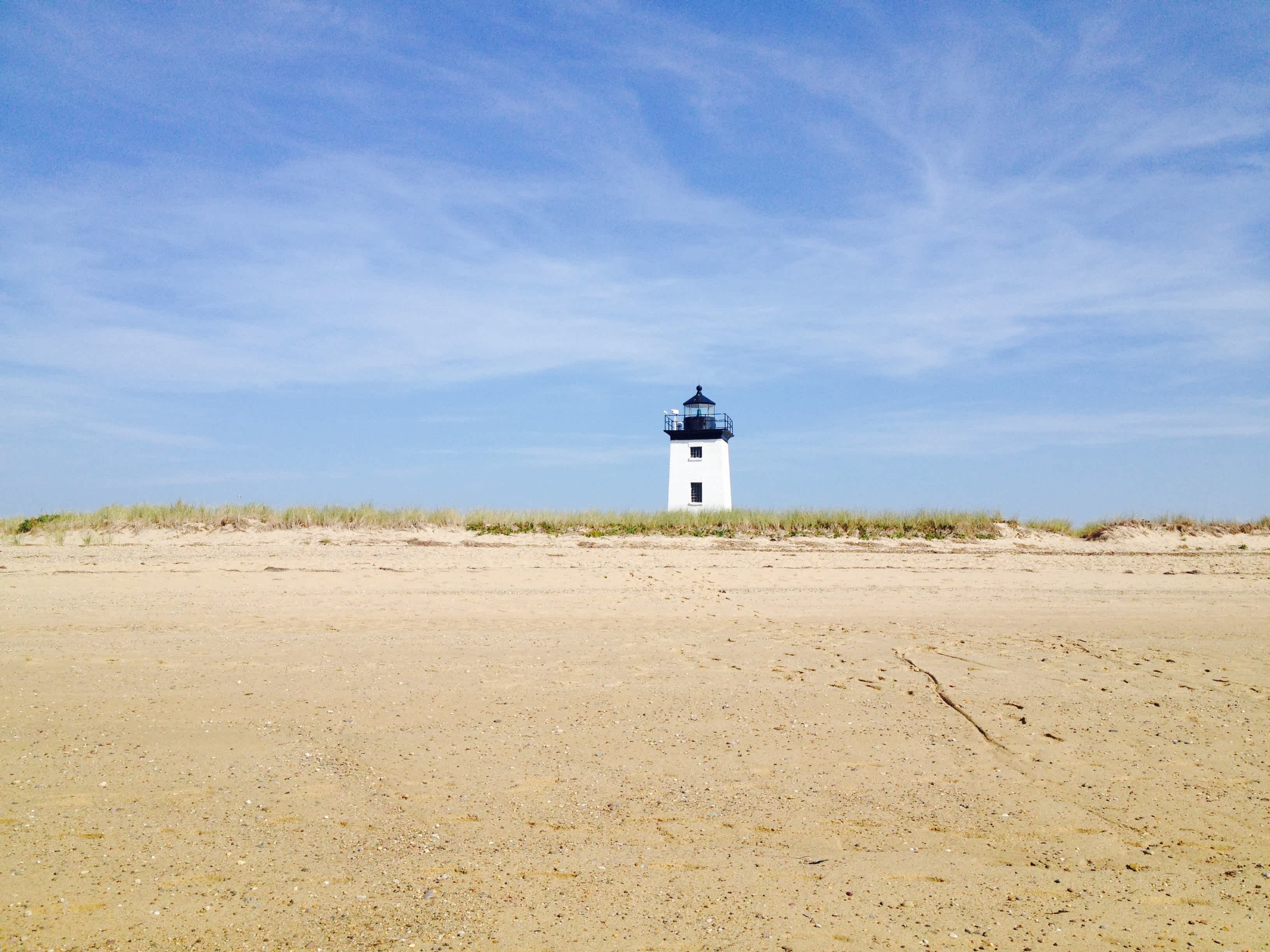 Long point lighthouse centered against blue skies and white cirrus clouds