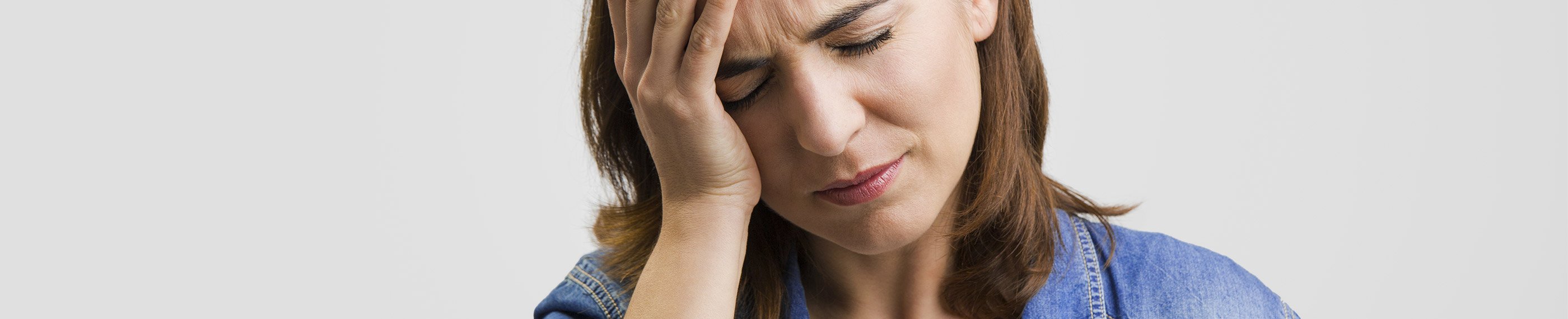 Personne se tenant la tête en signe de douleur