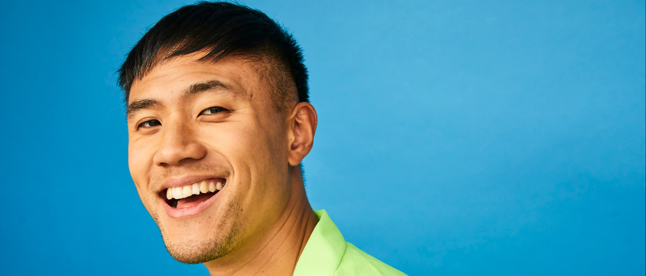 Young man with green shirt smiling