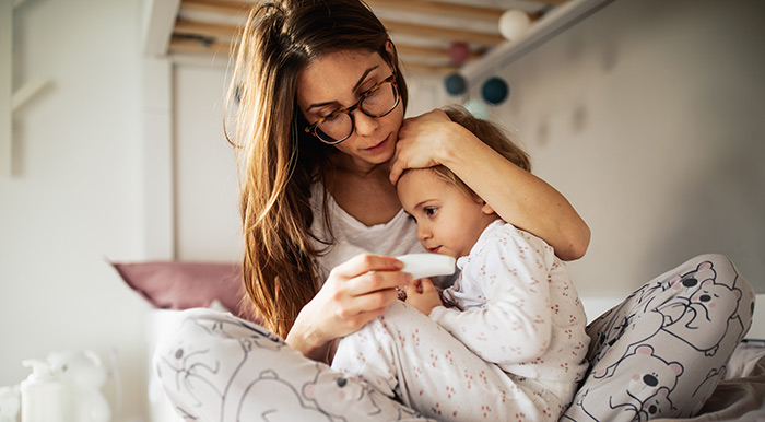 Femme prenant soin de son enfant malade à la maison