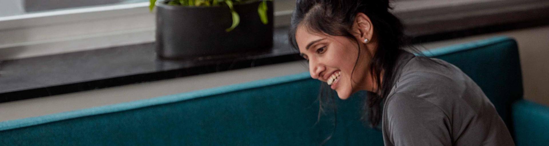 Une maman souriante assise dans son salon