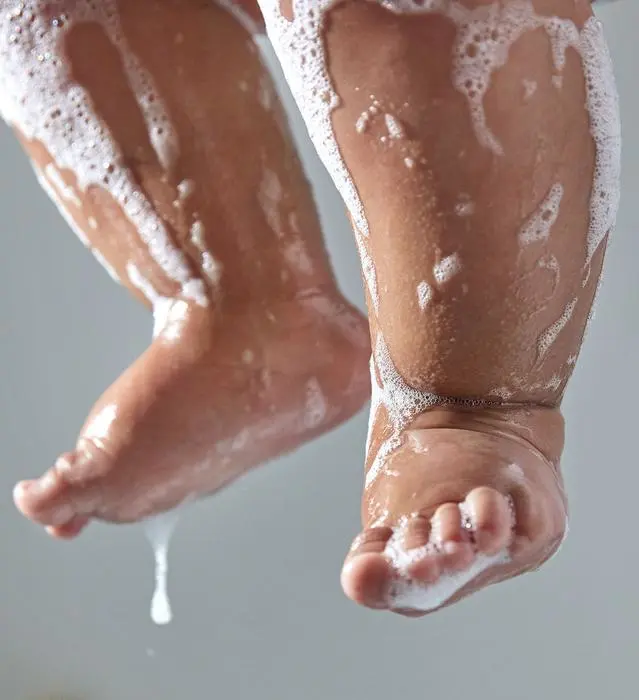 Des pieds de bébé recouverts de mousse