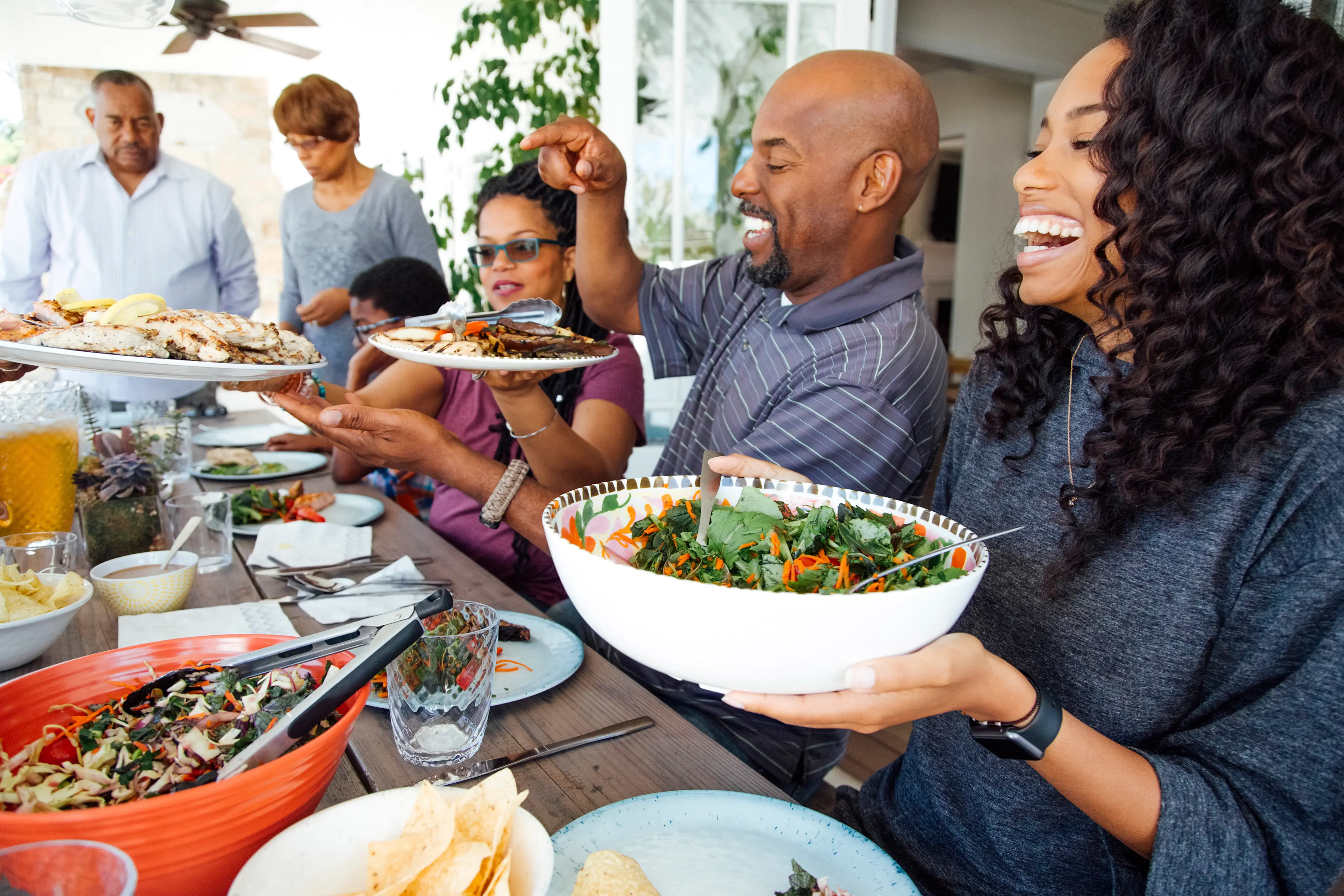 Joyful family and friends sharing a meal together at a gathering.