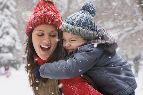 Toddler holding a mother's face and smiling