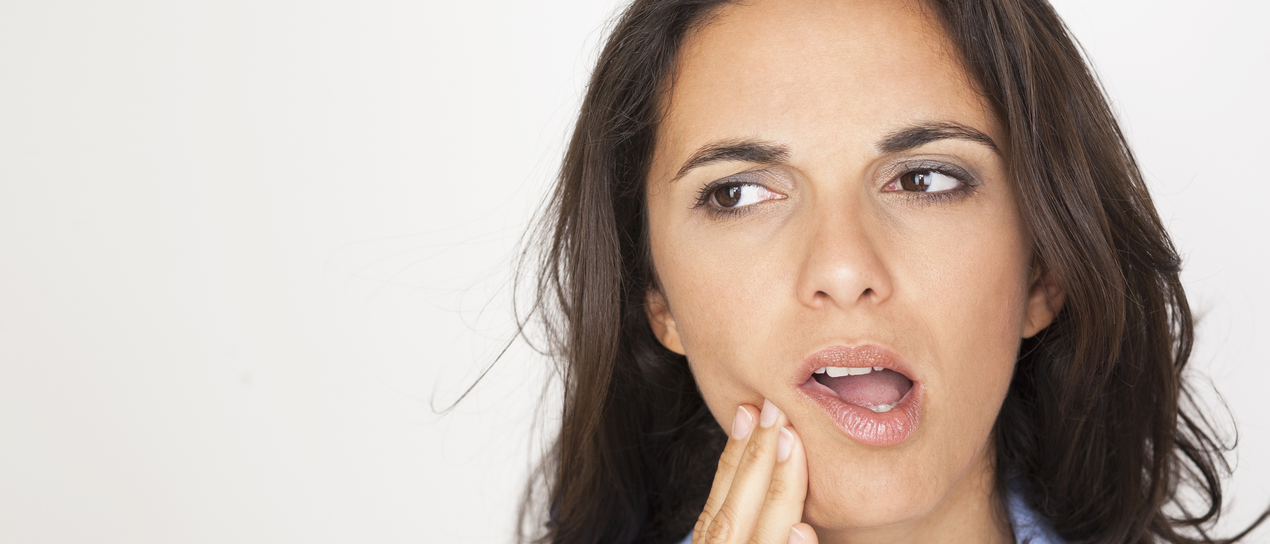 Young woman holding her jaw looking in pain