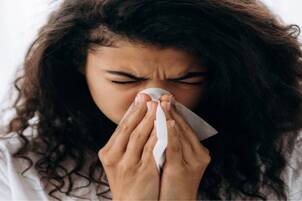 Woman with stuffy nose and a tissue