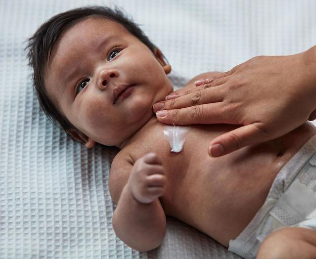 Massaging lotion on baby's skin