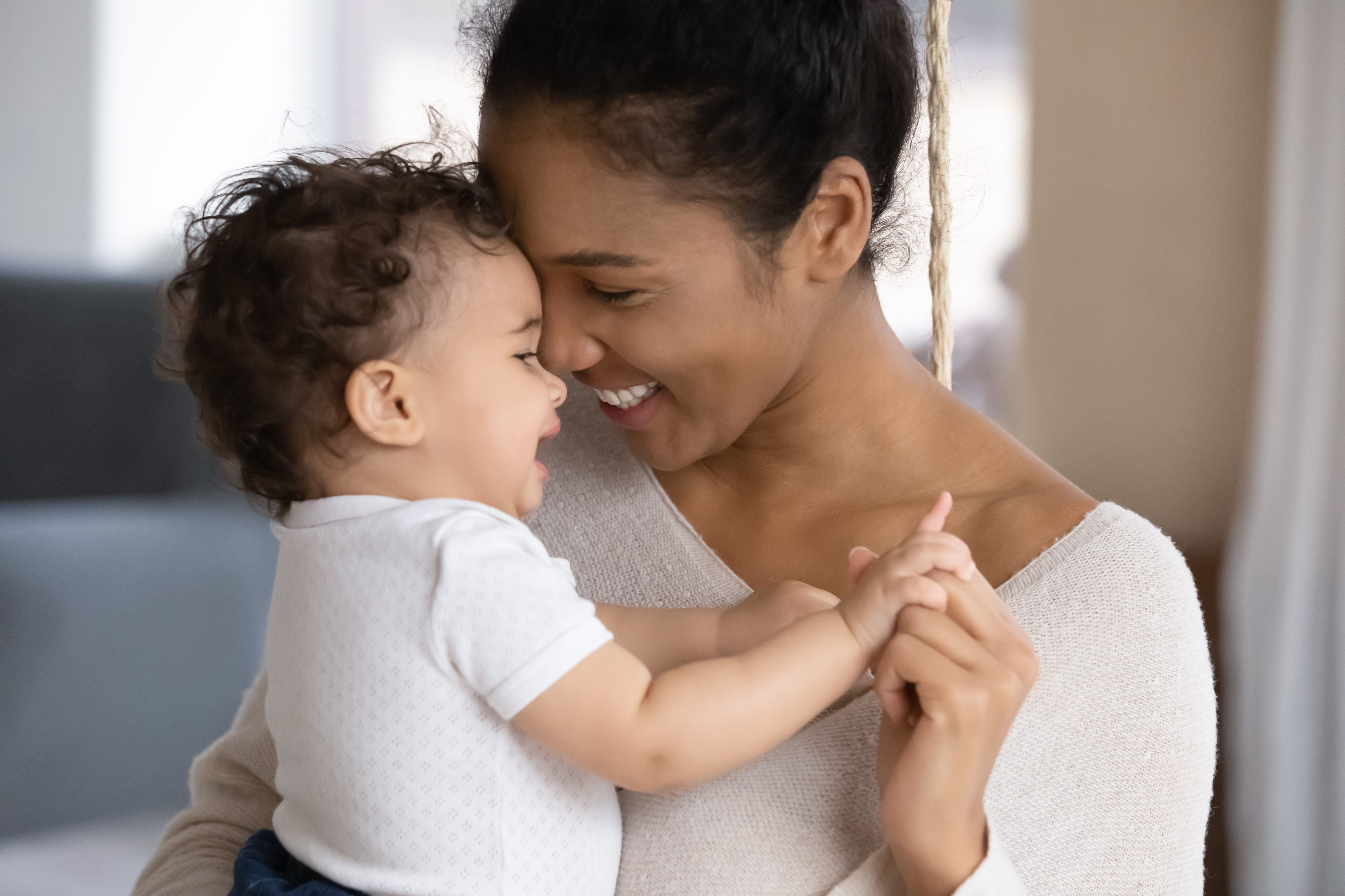 Femme qui tient un bébé en pleurs et le réconforte. 