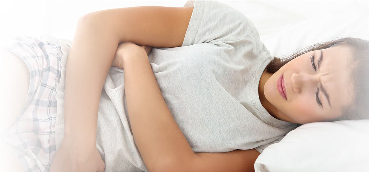 A woman lying in bed having menstrual pain