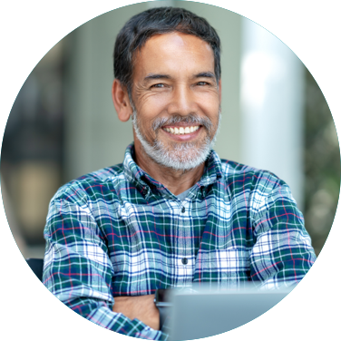 Man sitting outside with his laptop and smiling