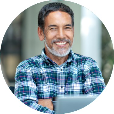 Man sitting outside with his laptop and smiling