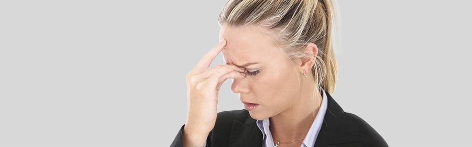 Woman placing her hand on her forehead while her head aches