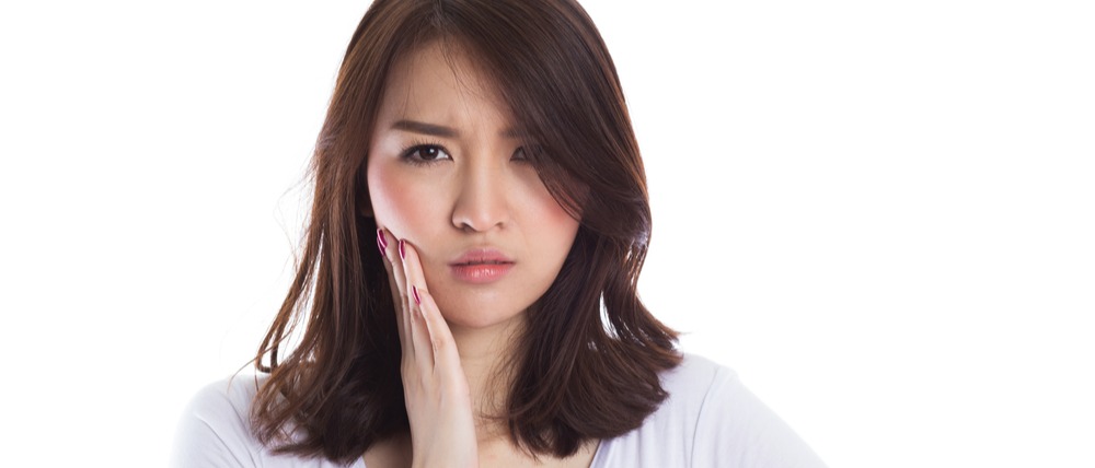 Young woman holding her jaw in pain