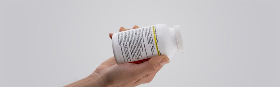 Hand holding a Tylenol bottle with the instructions showing