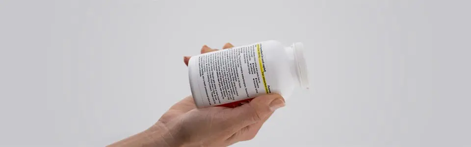 Hand holding a Tylenol bottle with the instructions showing