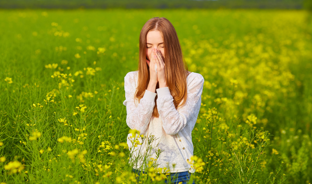 Woman covering her nose and mouth in a field