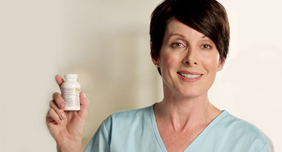 Woman smiling and holding up a bottle of Tylenol