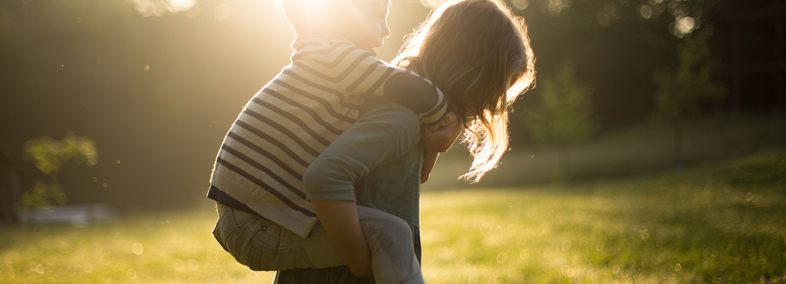 little girl carrying a boy on her back