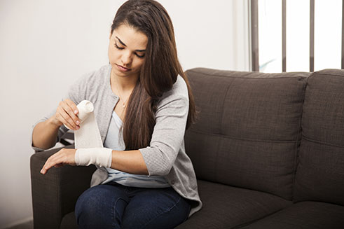 female wrapping hand with gauze