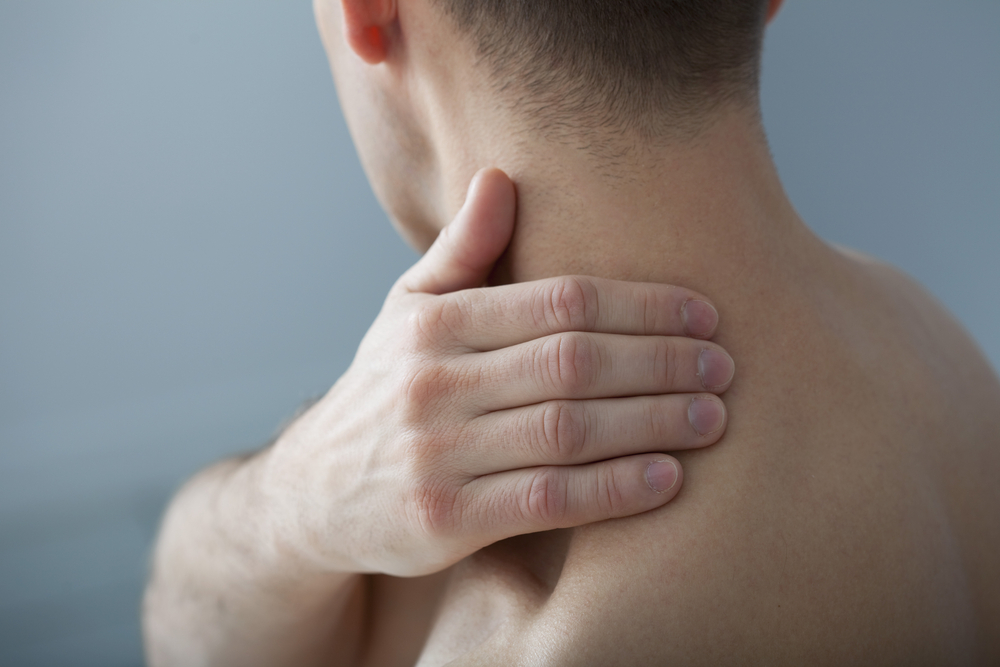 Un homme ressentant une tension musculaire au cou.