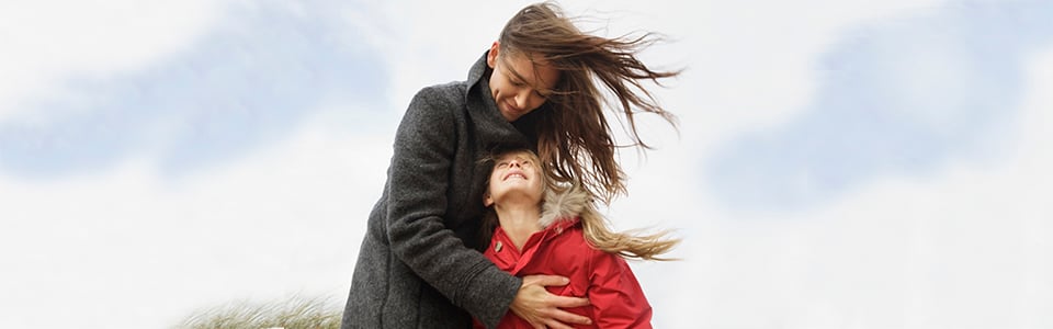 Mother hugging her daughter as she smiles